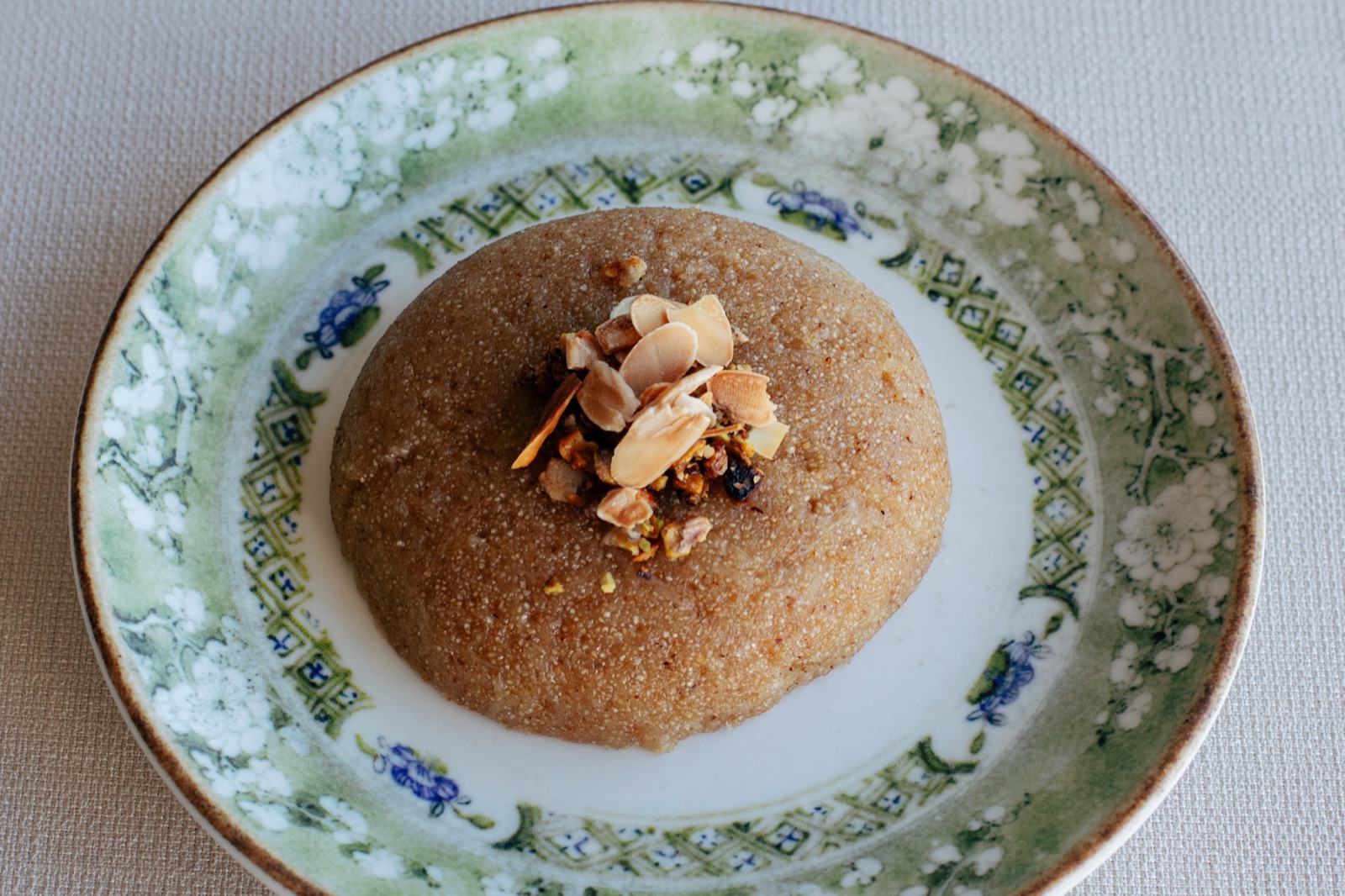 Shyra Restaurant - warm cheese semolina halva topped with roasted nuts on a patterned plate