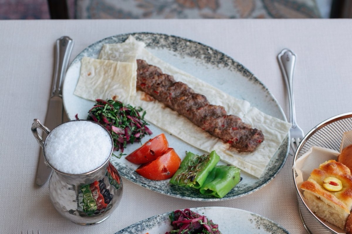 Shyra Restaurant - Adana kebab on lavash with grilled peppers, tomato and a copper cup of ayran