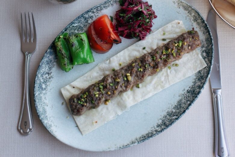 Shyra Restaurant - Pistachio kebab grilled over charcoal on flatbread with grilled peppers and tomato